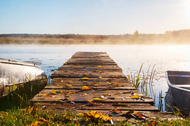 istock a long pier leading into the river, autumn leaves lie on the pie 1069790908