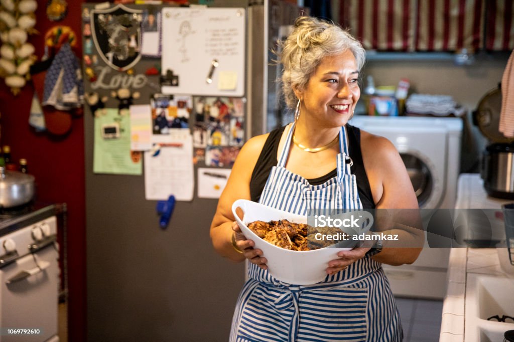 Hispanic Woman Making Dinner in Kitchen A mexican woman getting ready for family dinner Cooking Stock Photo