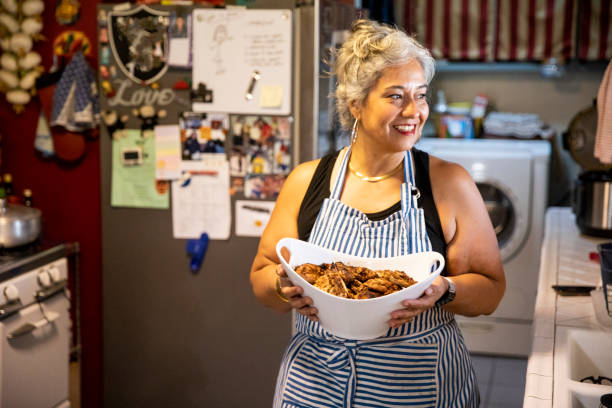 Hispanic Woman Making Dinner in Kitchen A mexican woman getting ready for family dinner woman making healthy dinner stock pictures, royalty-free photos & images