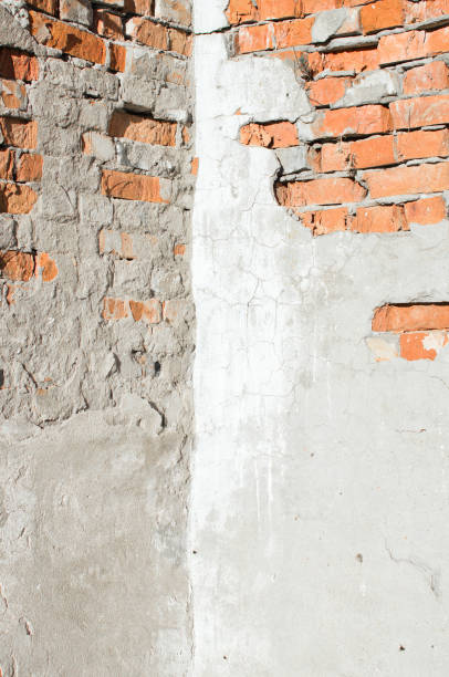 istock corner of an old weathered brick wall partially covered with crumbling concrete - background image 1069792790