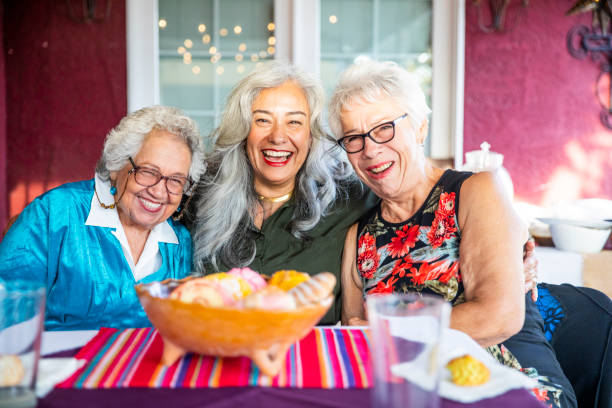 istock Three Mexican Ladies Smiling with Sweet Bread 1069798376