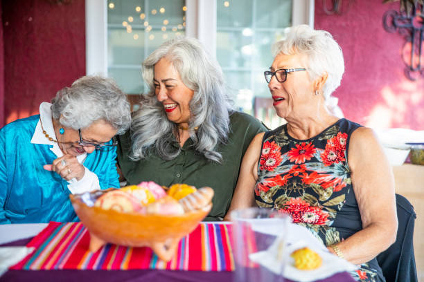 istock Three Mexican Ladies Smiling with Sweet Bread 1069798422