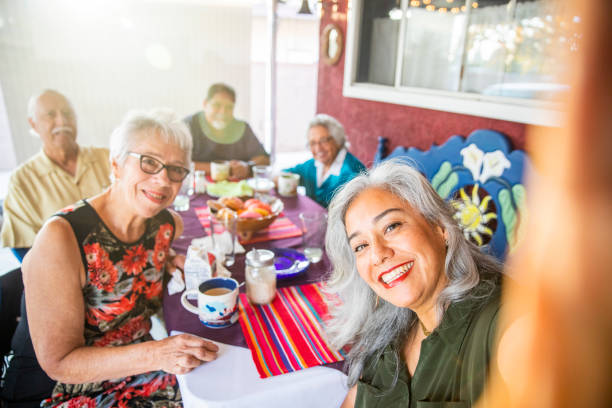 Mexican Family Takes a Selfie at Dinner A mexican family enjoys a dinner out on the patio at home. typical average stock pictures, royalty-free photos & images