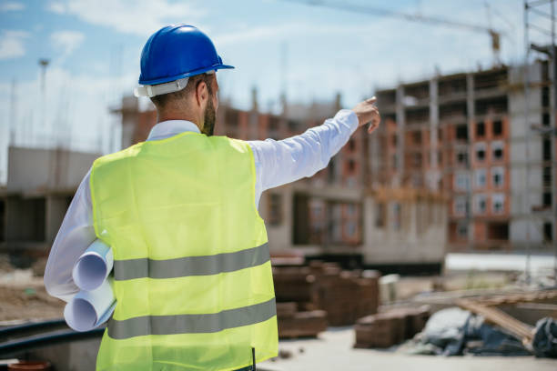 istock Young architect with blueprint and blue helmet 1069798698