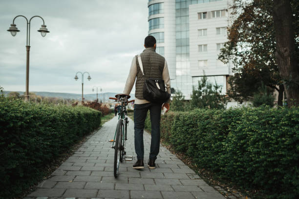 istock Handsome man with a bicycle having a coffee break in the park 1069800150