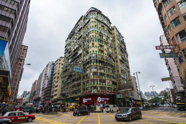 Run-down building at the junction of Nathan Road and Jordan Road, one of most densely populated areas in the world, Hong Kong, Kowloon Run-down building at the junction of Nathan Road and Jordan Road, one of most densely populated areas in the world. Hong Kong, Kowloon, January 2018 chinese slum stock pictures, royalty-free photos & images
