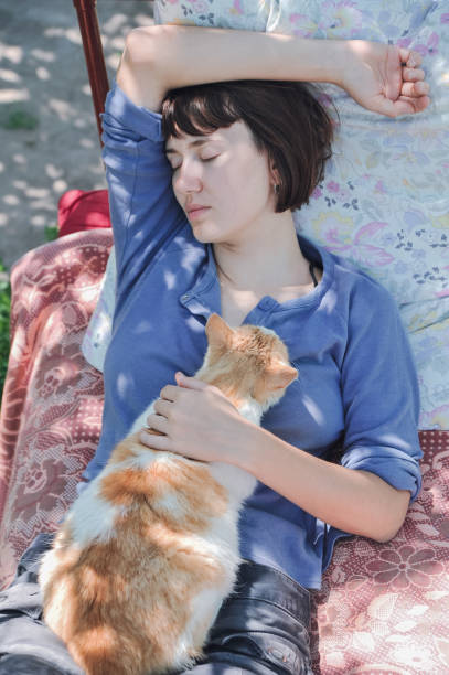 istock Young woman is resting with ginger cat outdoor 1069803116