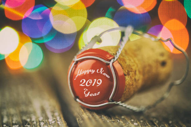 istock Champagne cork on a rustic wooden table in front Christmas tree 1069834048