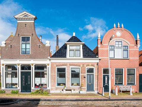 WORKUM, NETHERLANDS - OCT 5, 2017: Front view of three historic houses in old town of Workum, Friesland, Netherlands