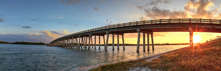 Sunset over Bridge along Estero Boulevard, crossing over New Pass from Estero Bay in Bonita Springs, Florida.