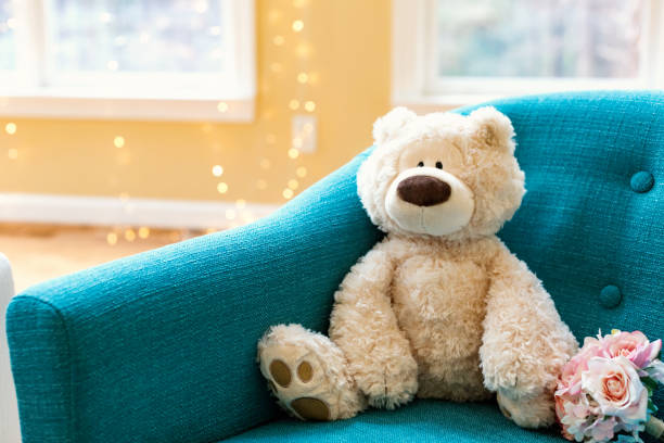 Teddy bear and a flower bouquet on a chair in a room