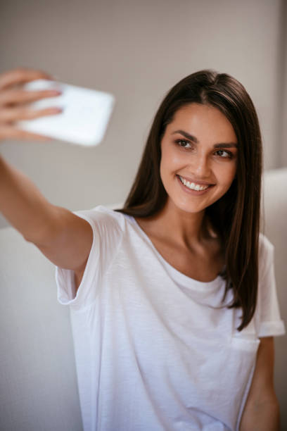 istock Young woman taking selfie at home 1069846192