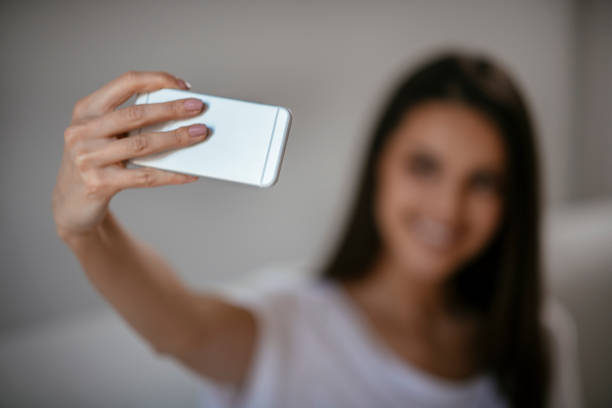istock Young woman taking selfie at home 1069846234