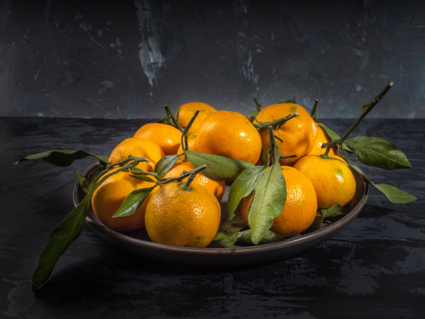 istock fresh mandarin fruit with leaf on dark background, fir branches 1069846412