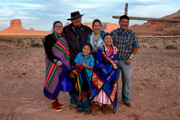 Happy Navajo Family Happy young family of Navajo people posing and laughing together on their land in Monument Valley Arizona navajo stock pictures, royalty-free photos & images