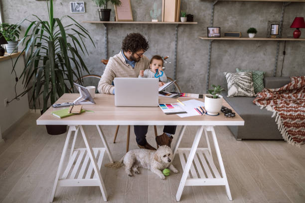 istock Father, Baby and dog in home office 1069854656