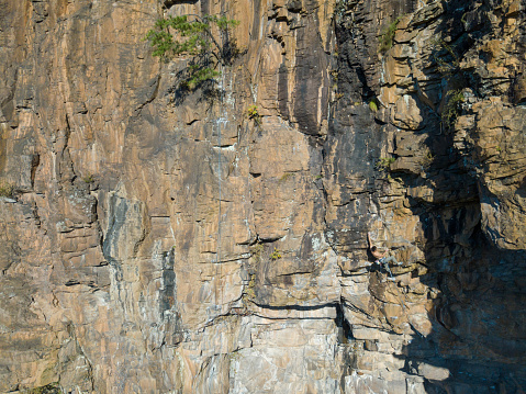 Aerial view of a mid adult man rock climbing in an extreme location in the mountains of Japan