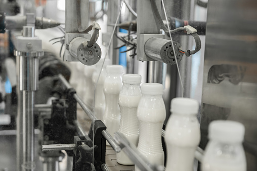plastic milk bottles on conveyor belt. equipment at the dairy plant