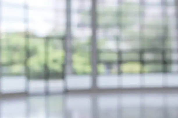 Photo of Blur background interior view looking out toward to empty office lobby and entrance doors and glass curtain wall