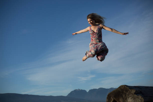 istock Ninja like jump female air blue sky background 1069878094
