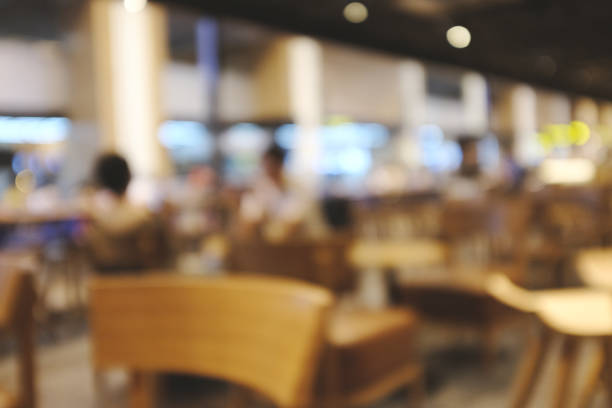istock Blurred background image of modern coffee shop. abstract blur background with people in cafe. warm color tone style