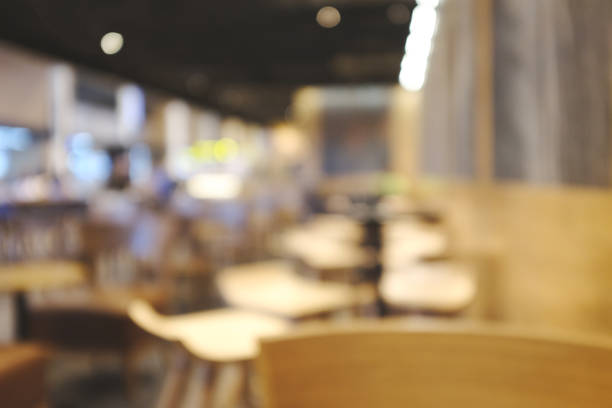 istock Blurred background image of modern coffee shop. abstract blur background with people in cafe. warm color tone style