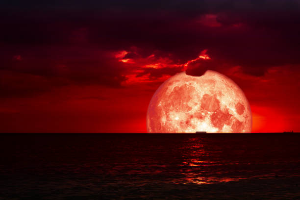 istock half red blood moon on night sea and back silhouette red cloud 1069892628