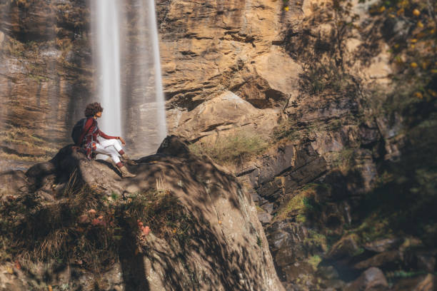 istock woman stops to view the waterfall up close 1069894984