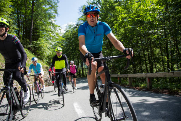 gruppe von rennradfahrer fahren rennräder auf bergstraße - cyclist cycling road women stock-fotos und bilder