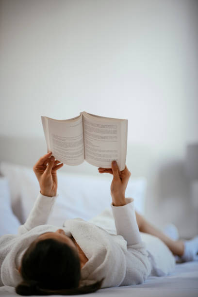 istock Woman reading book in bedroom 1069897936