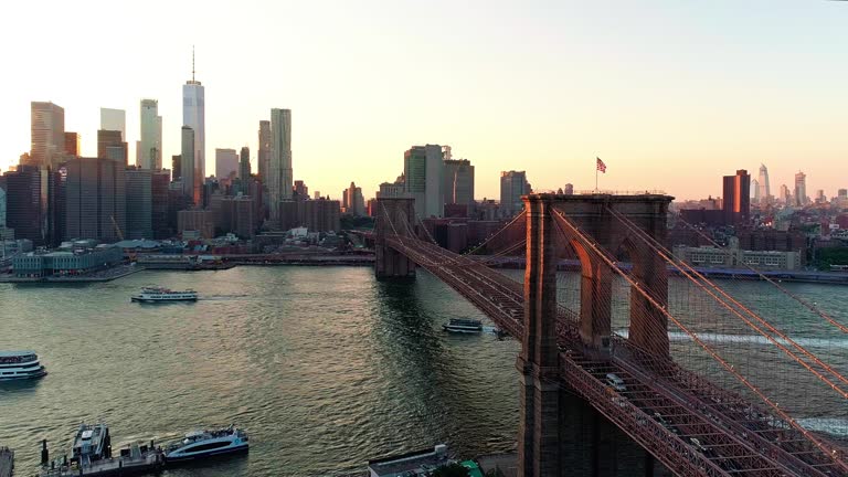 The aerial scenic view to Manhattan Downtown and Brooklyn Bridge from Brooklyn Heights over the East River at the sunset.