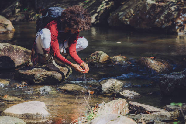 istock woman stops to view the waterfall up close 1069905674
