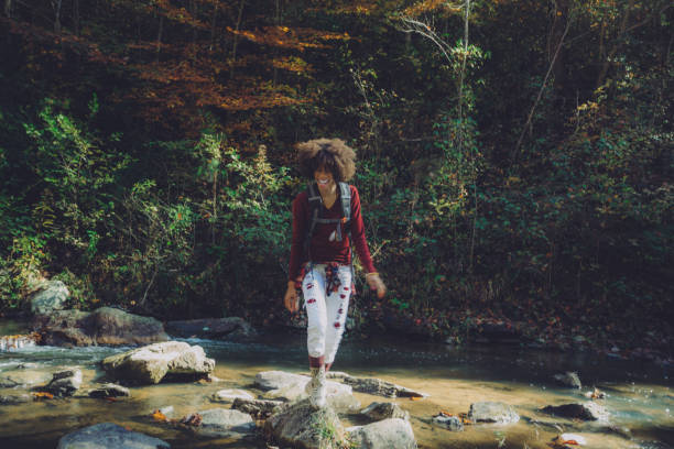istock woman stops to view the waterfall up close 1069905682
