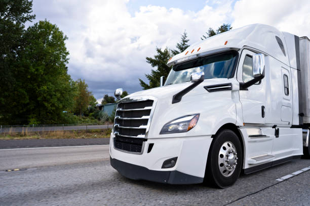 istock Comfortable white modern big rig semi truck running on divided highway 1069913158