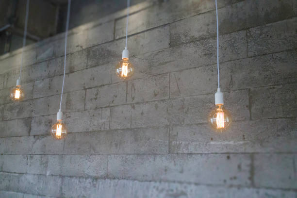 istock Vintage incandescent Edison type bulb on grey wall 1069913240
