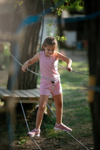 istock Girl on hinged trail in extreme rope park 1069915542