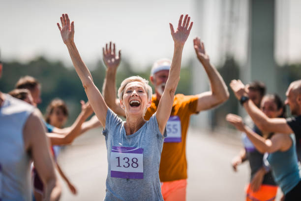 успешное завершение марафонской гонки! - senior adult running jogging senior women стоковые фото и изображения