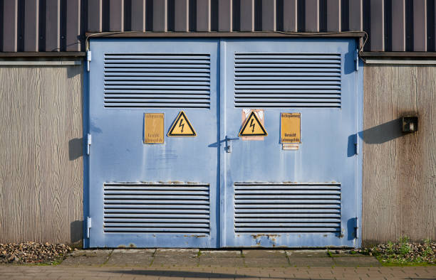 deux vieilles portes en acier industrielles avec panneaux d’avertissement - garage sale flash photos et images de collection