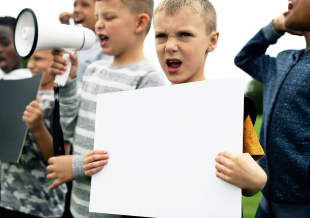 istock Young boy showing a blank paper in a protest 1069924330