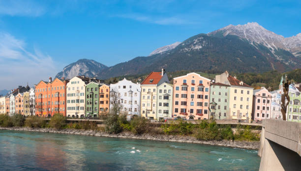 casas coloridas pelo rio inn, com as montanhas ao fundo no mariahilfstrasse em innsbruck, áustria - mariahilfstrasse - fotografias e filmes do acervo