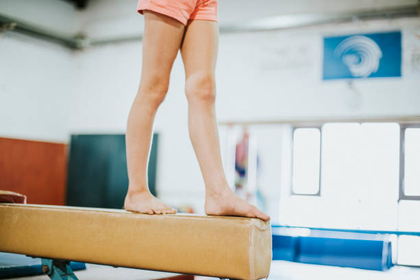 joven gimnasta equilibrio sobre una viga de equilibrio - barra de equilibrio fotografías e imágenes de stock