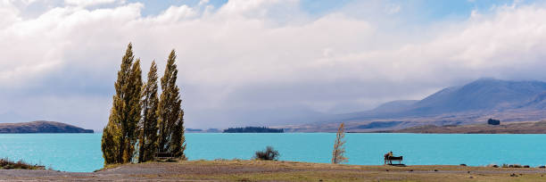 istock Couple Sitting On A Bench By A Lake 1069926970
