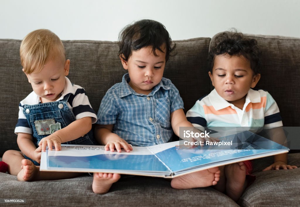 Three little boys reading a book on a sofa Three little boys reading a book on a sofa
***These are our own generic designs. They do not infringe on any copyrighted designs. Baby - Human Age Stock Photo