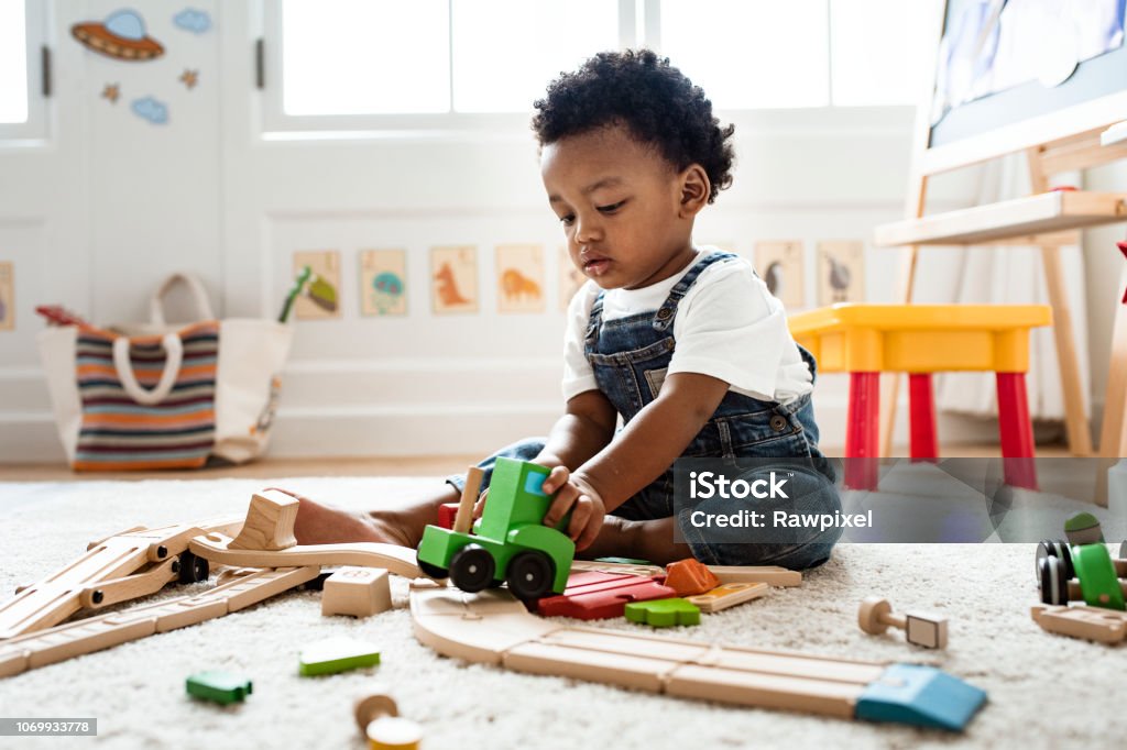 Menino bonitinho brincando com um brinquedo de trem da estrada de ferro - Foto de stock de Criança royalty-free