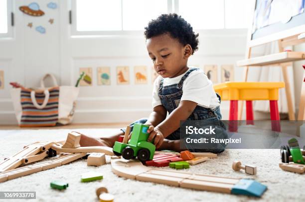 Foto de Menino Bonitinho Brincando Com Um Brinquedo De Trem Da Estrada De Ferro e mais fotos de stock de Criança