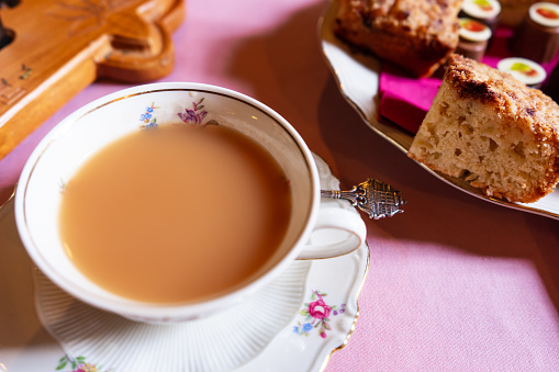 Cup of tea on floral plate with coffee cake from above