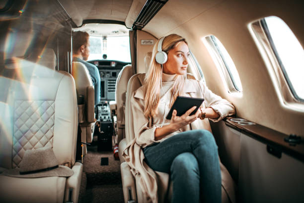 jeune femme assise dans un avion privé - status symbol audio photos et images de collection