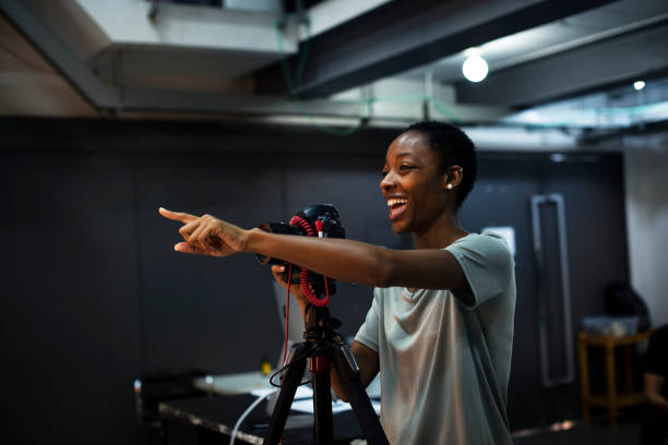 fotografo allegro che dà istruzioni in studio - director foto e immagini stock