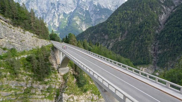 istock Five men and women riding road bikes on bridge 1069941302