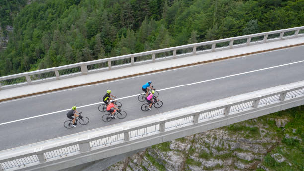 istock Five men and women riding road bikes on bridge 1069941306